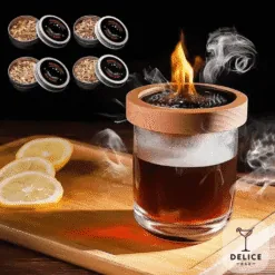 Verre de whisky fumant coiffé du fumoir en bois enflammé avec boîtes de copeaux et citron Délice Bar