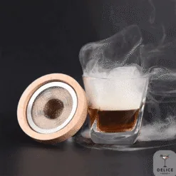 Couvercle fumoir rond en bois avec filtre à côté d'un verre de whisky fumant Délice Bar