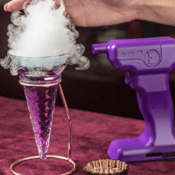 Verre cornet violet sur support cuivré coiffé d'une bulle de fumée blanche, pistolet à arômes violet