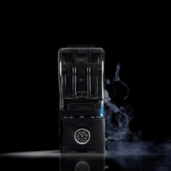 Máquina de hielo seco negra difundiendo humo azulado sobre fondo oscuro