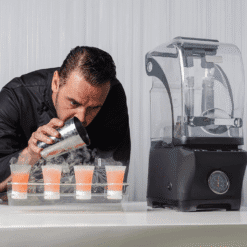 Bartender bebiendo un chupito humeante junto a varios vasos y una máquina de hielo seco Jetchill negra