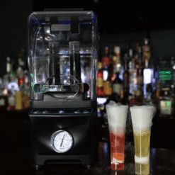 Máquina Jetchill Dry Ice Pro negra en la barra con dos cócteles humeantes, uno rojo y otro amarillo