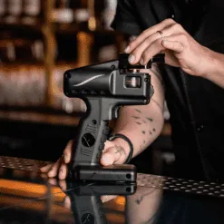 Barman utilisant le pistolet Flavour Blaster Pro 2.5 noir posé sur un comptoir de bar