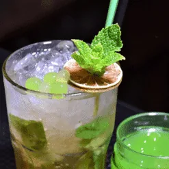 Iced Mojito cocktail garnished with mint, dried lemon and green lime Mojito pearls