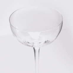 Gros plan du calice transparent d'un verre à bulle coupe pour cocktail à pied fin