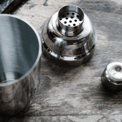 Shaker cobbler Madison démontré en trois pièces, gobelet, passoire filtrante et capuchon, sur bois