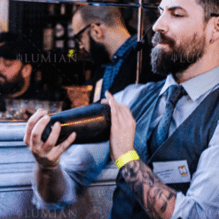 Barman secouant le shaker Parisien Zeus noir lors d'une demonstration de cocktail en bar