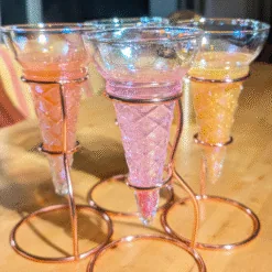 Trois verres cornet pailletés rose et doré sur support spirale cuivré pour cocktails festifs