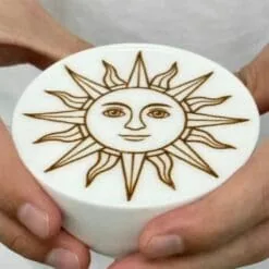 Tasse de mousse tenue à deux mains avec soleil à visage imprimé par l'imprimante alimentaire