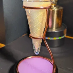 Verre à cocktail en cornet de glace sur support spirale en métal cuivré, boisson rose nacrée