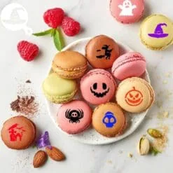 Piatto di macarons colorati decorati con stencil Halloween con motivi di fantasma, zucca, strega e ragno per dessert a tema
