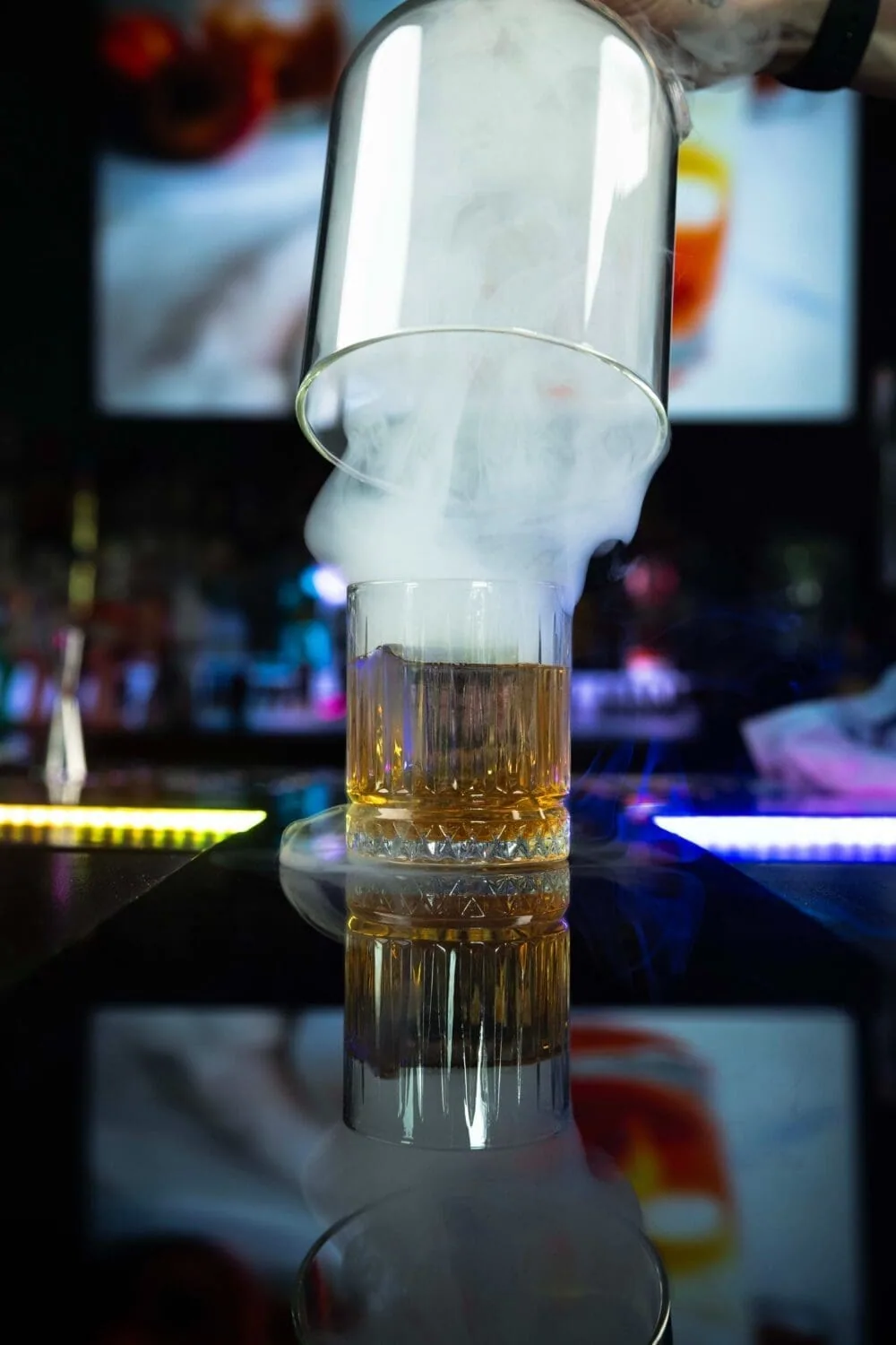Cocktail présenté sous une cloche remplie de fumée