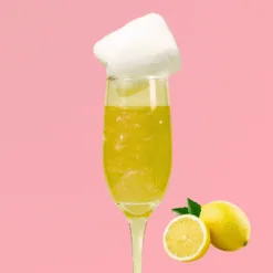 Flûte de cocktail jaune citron pétillant garnie de barbe à papa blanche et citrons frais