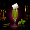 Cocktail vert menthe pailleté avec barbe à papa sur fond noir Délice Bar